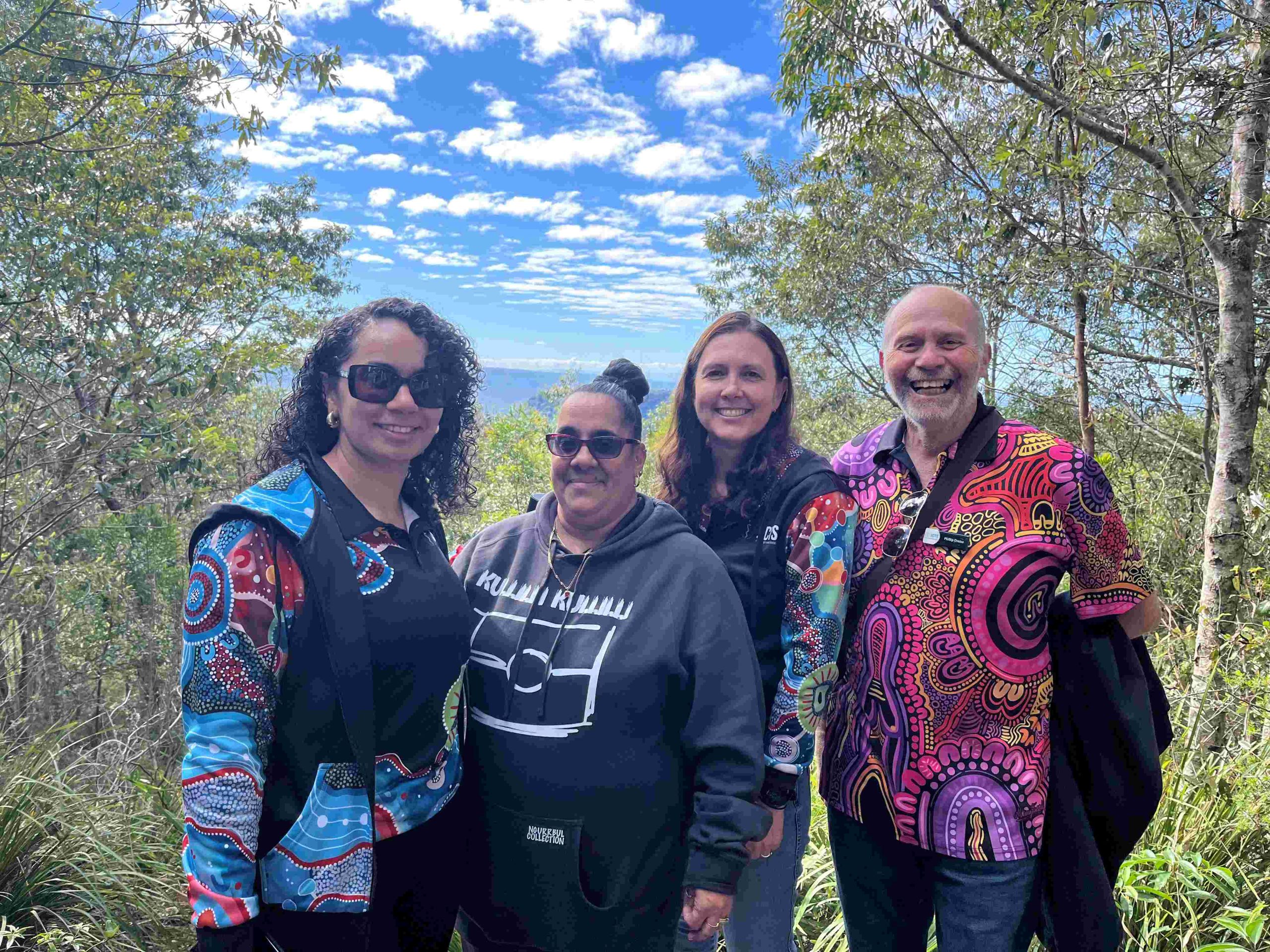 People standing outside in front of a scenic background in Queensland